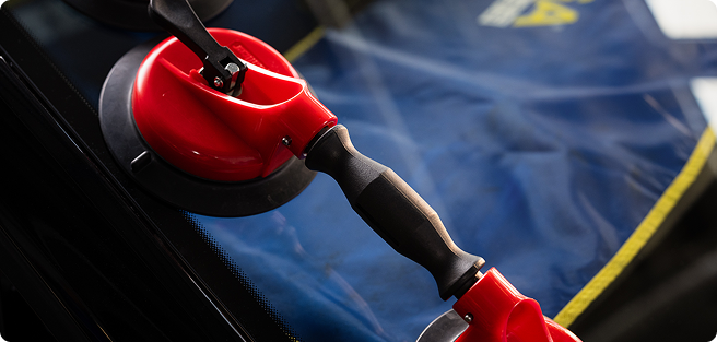 Man gluing plastic on glass with a tool